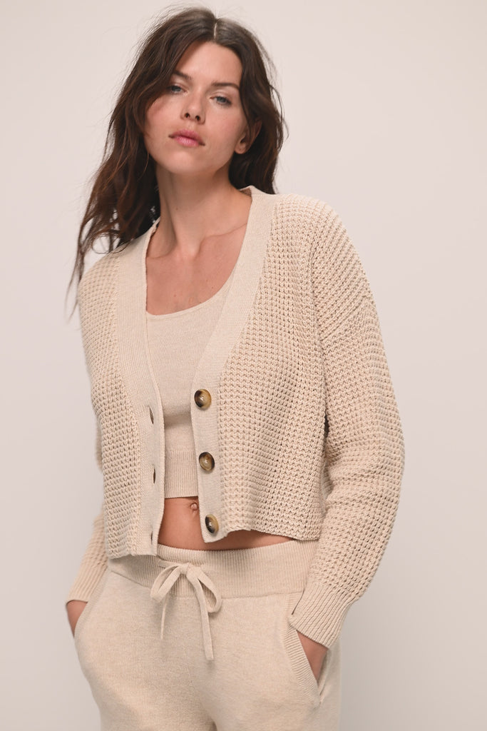Model wears Recycled Sweater Cropped Cardigan in Oat.