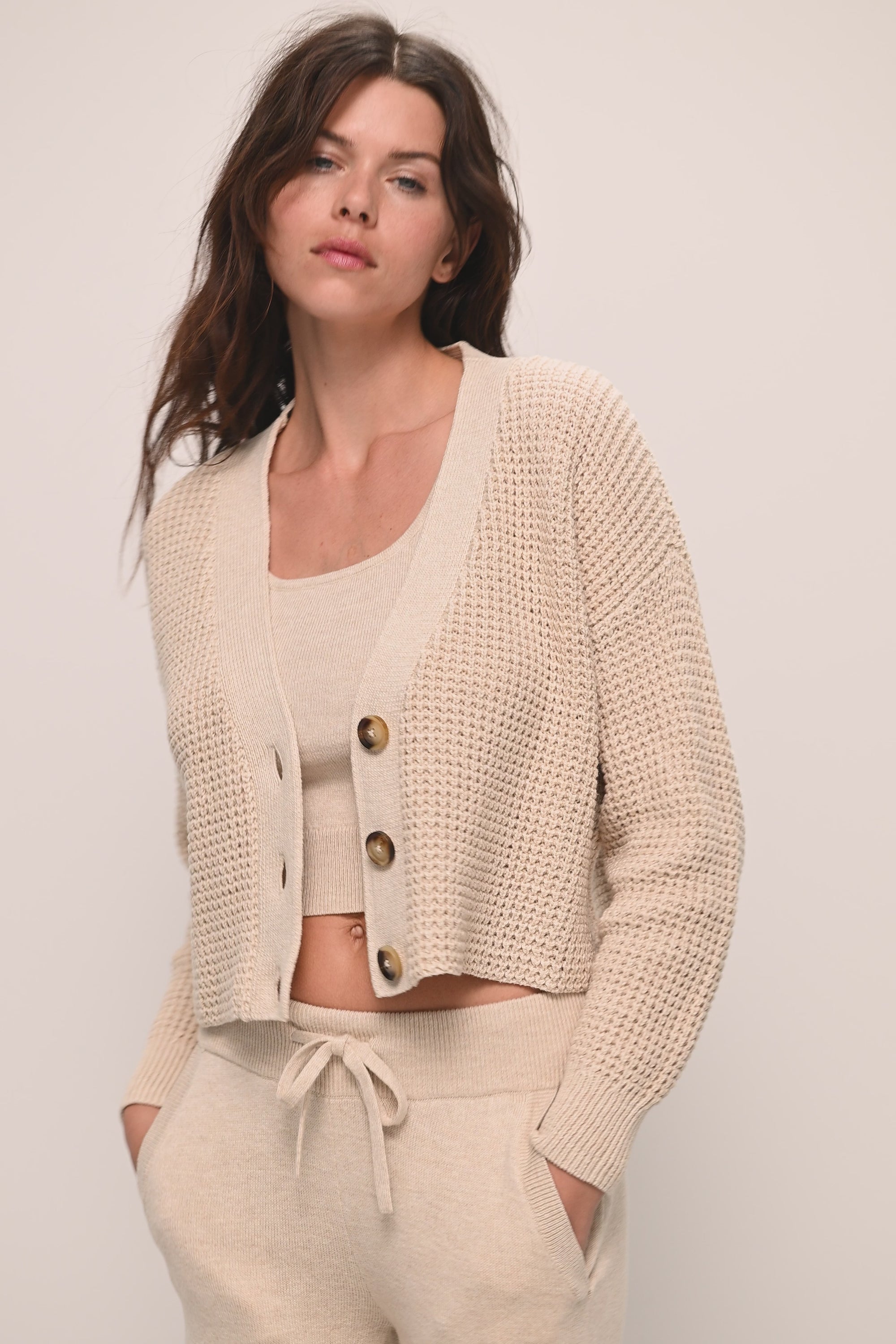 Model wears Recycled Sweater Cropped Cardigan in Oat.