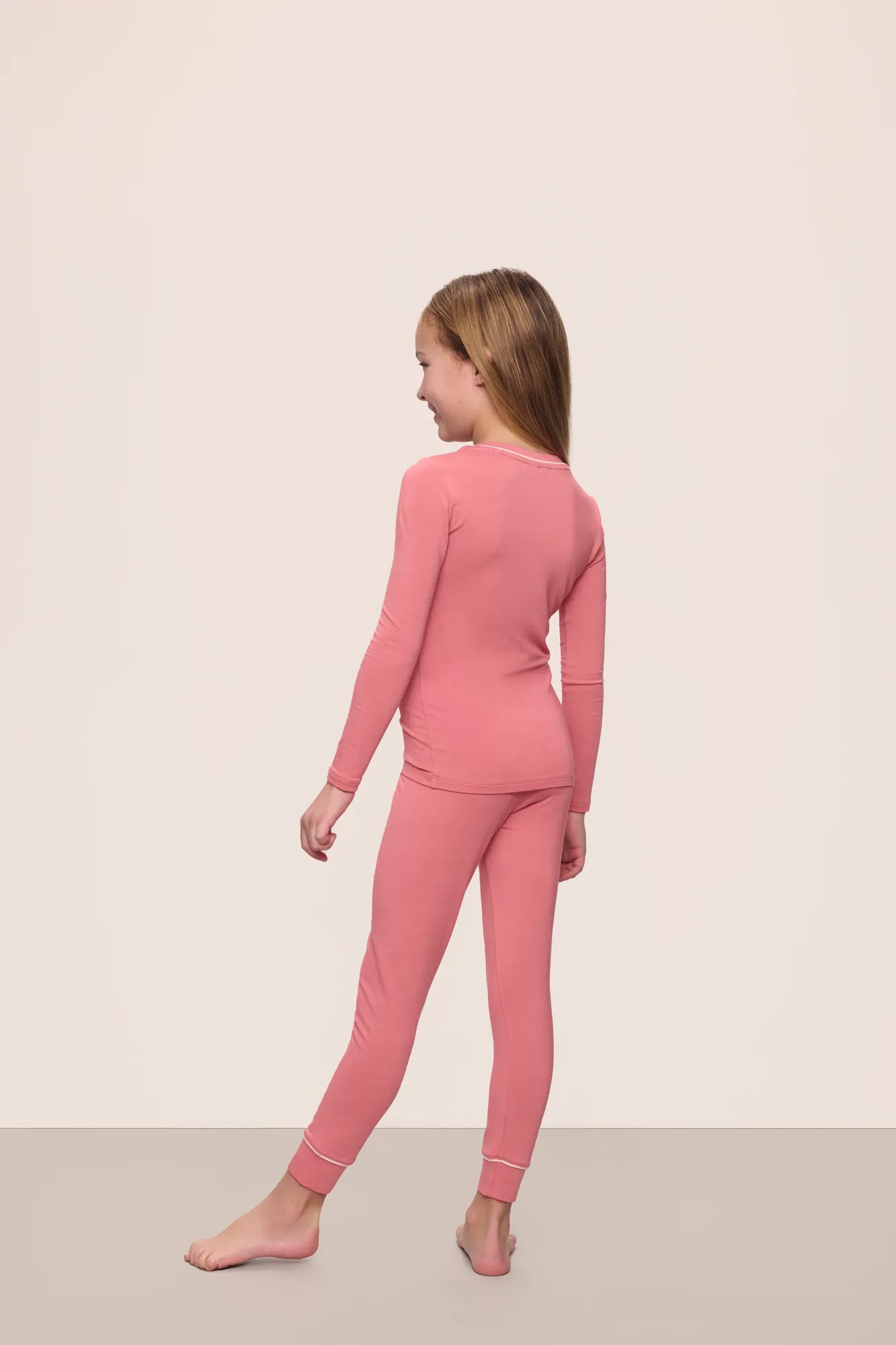 Model wearing Kids TENCEL™ Modal Unisex Long PJ Set in Sunkissed Coral/Ivory