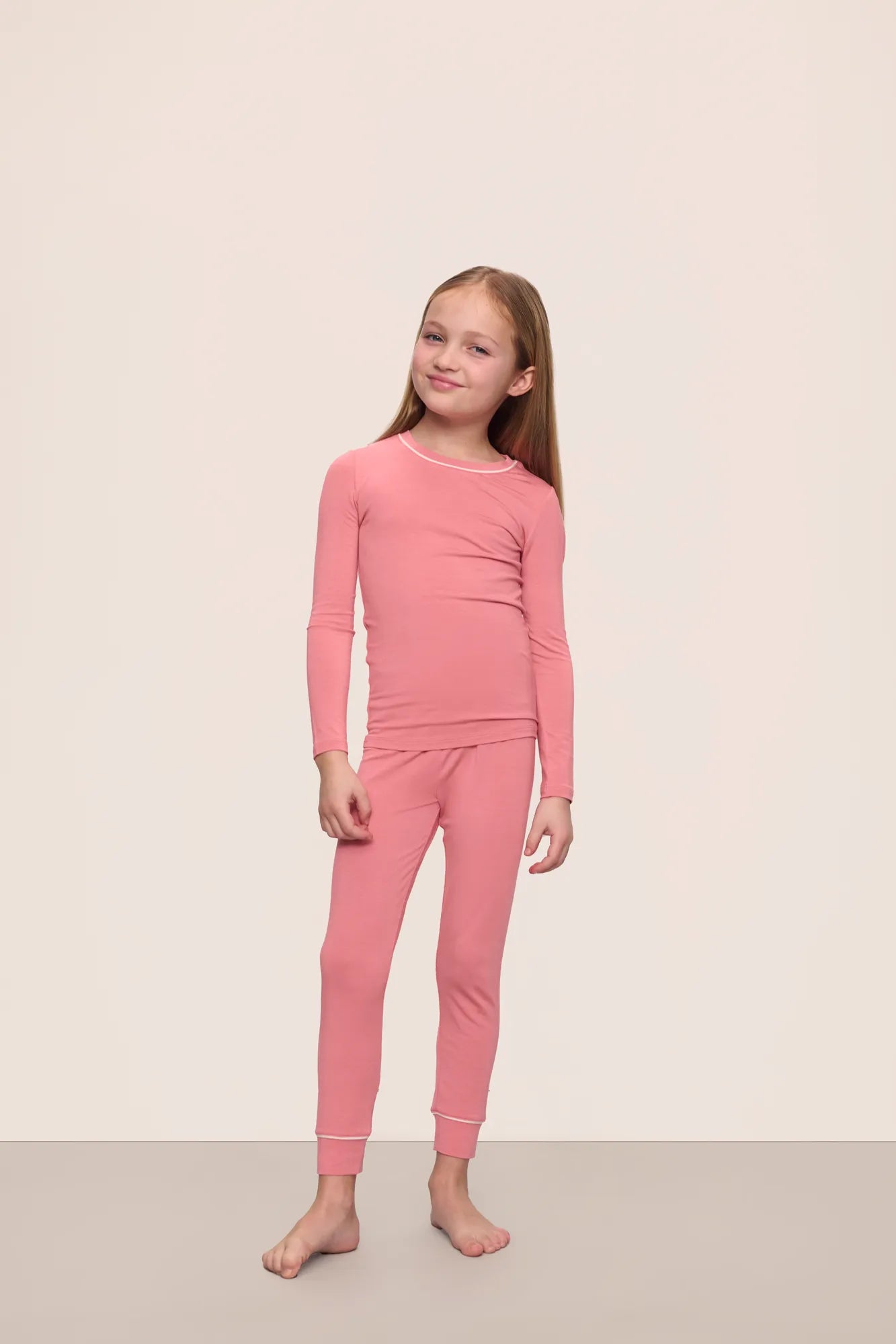 Model wearing Kids TENCEL™ Modal Unisex Long PJ Set in Sunkissed Coral/Ivory