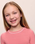 Model wearing Kids TENCEL™ Modal Unisex Long PJ Set in Sunkissed Coral/Ivory