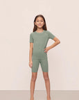 Model is wearing Kids TENCEL™ Modal Unisex Short PJ Set in Eucalyptus/Ivory