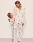 Model is wearing Gisele Printed TENCEL™ Modal Long PJ Set in Floral Bloom Ivy/Vanilla Cream with kids' model in Kids Printed TENCEL™ Modal Unisex Long PJ Set in Floral Bloom Ivy/Vanilla Cream