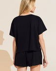 Model wears Organic Linen Knit Short Sleeve T-Shirt in Black.
