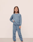Model is wearing Kid's French Terry Sweatshirt and Jogger Set in Faded Denim