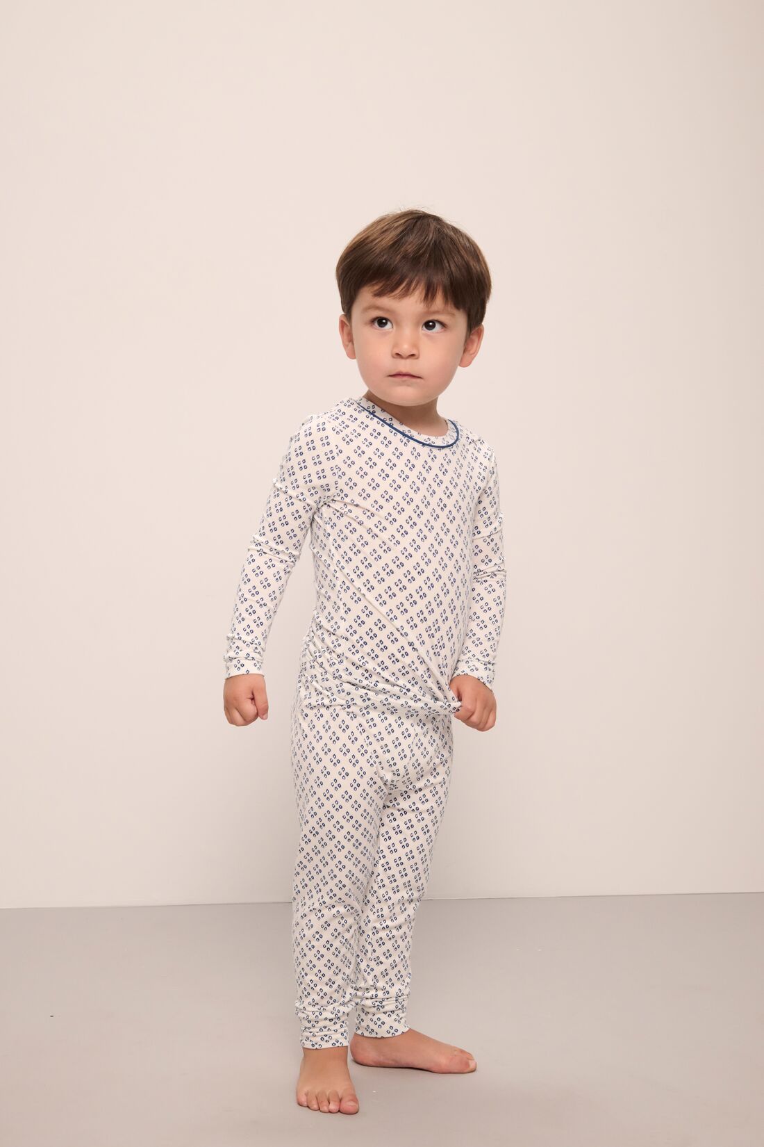 Model wears Kids Printed TENCEL™ Modal Unisex Long PJ Set in Petite Batik Ivory/Denim Blue.