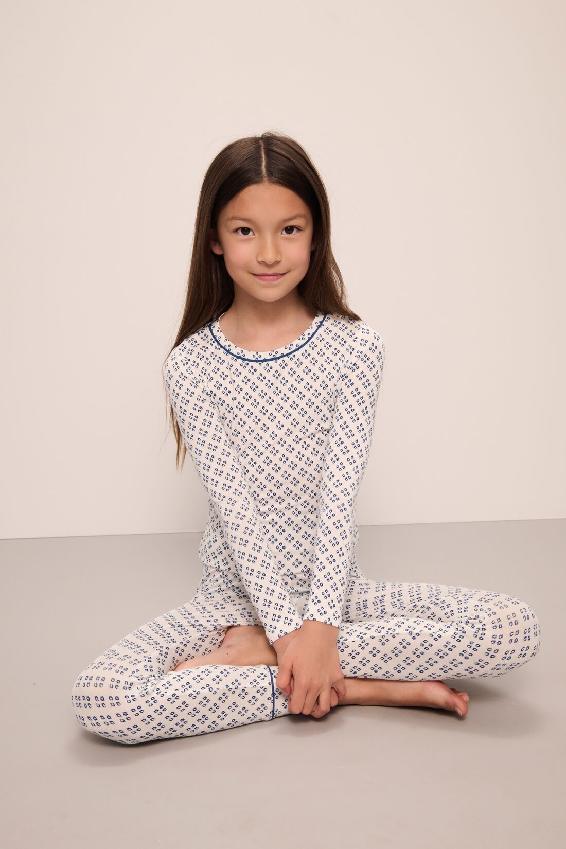 Model wears Kids Printed TENCEL™ Modal Unisex Long PJ Set in Petite Batik Ivory/Denim Blue.