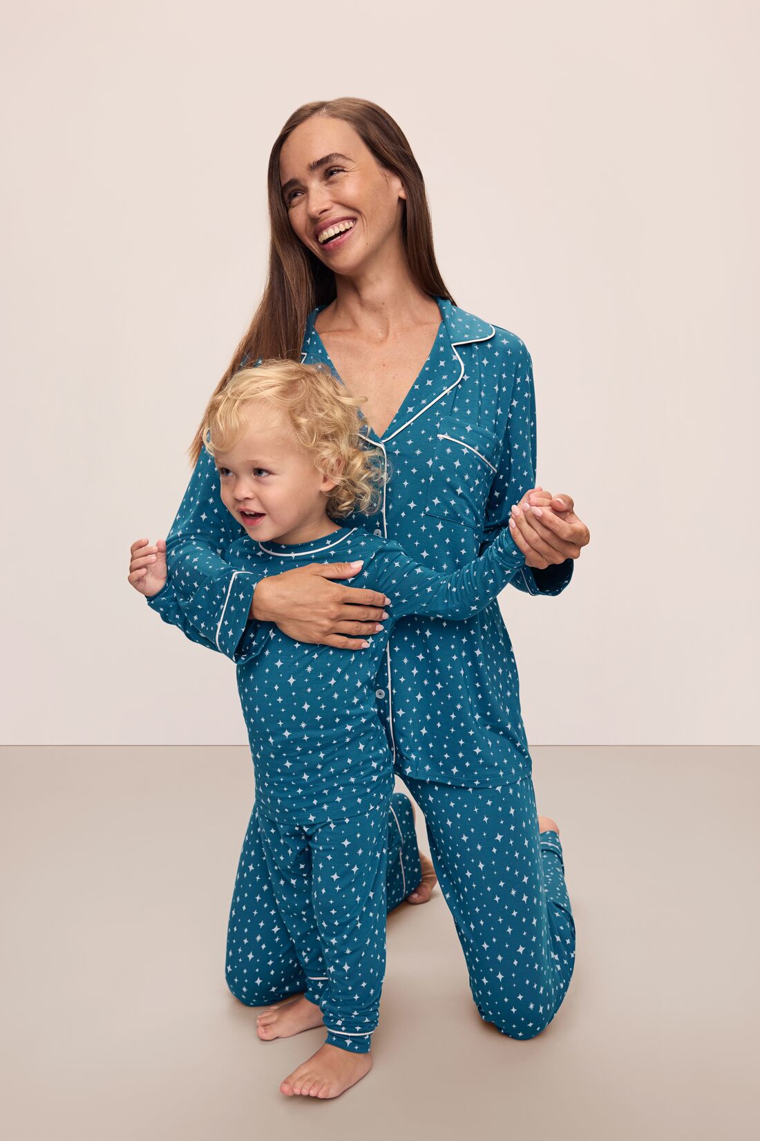Model is wearing Kids Printed TENCEL™ Modal Unisex Long PJ Set in Festive Lights Sapphire/Ivory.