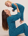 Model is wearing Kids Printed TENCEL™ Modal Unisex Long PJ Set in Festive Lights Sapphire/Ivory.