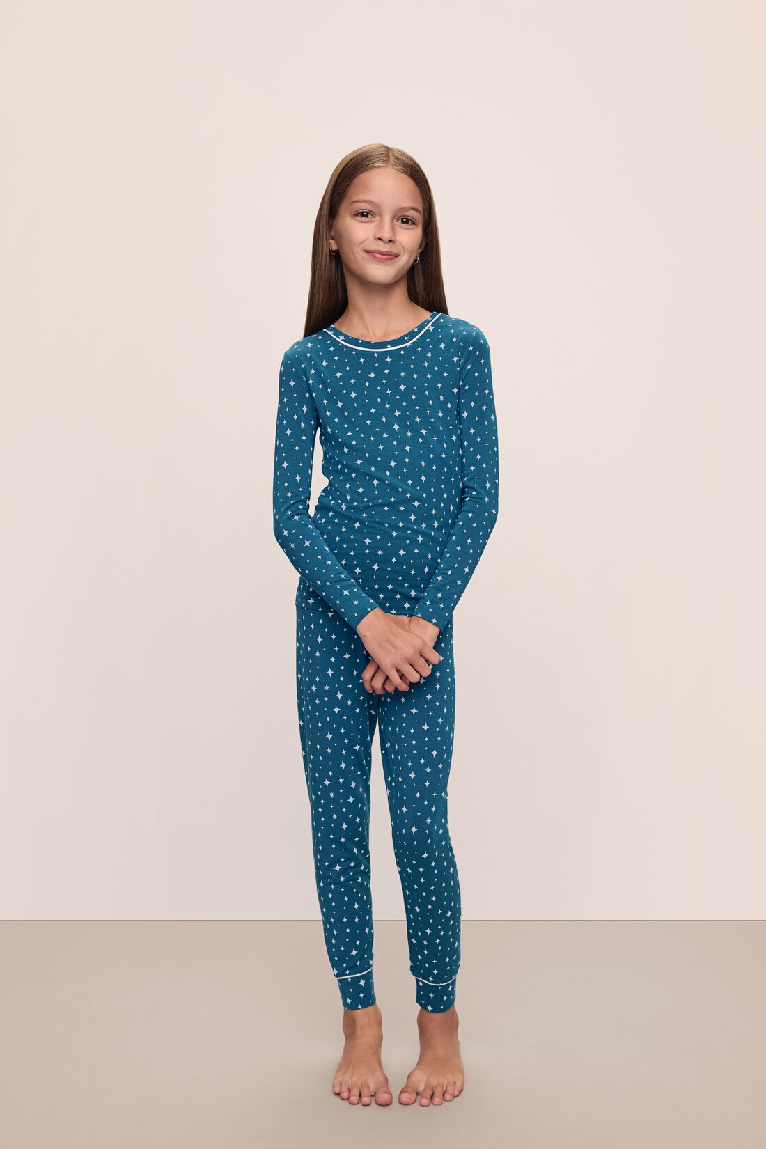 Model is wearing Kids Printed TENCEL™ Modal Unisex Long PJ Set in Festive Lights Sapphire/Ivory.