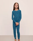 Model is wearing Kids Printed TENCEL™ Modal Unisex Long PJ Set in Festive Lights Sapphire/Ivory.