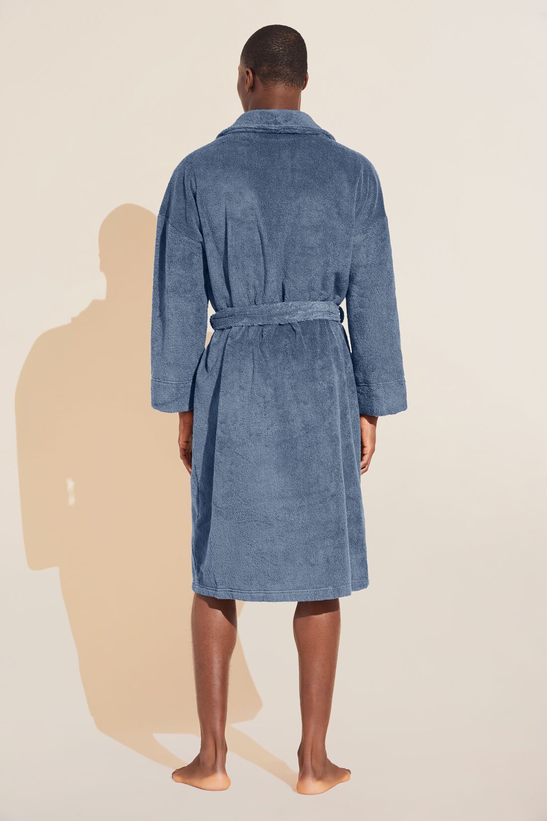 Model wears Terry Gender Neutral Robe in Coastal Blue.